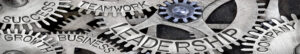Metal gears with "success, growth, business, teamwork, leadership, company" engraved on them.