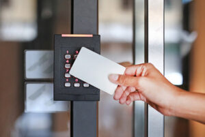 Depiction of keycard being used on number combination keypad to allow entry to door through keycard.