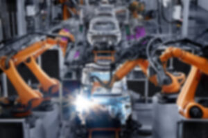 blurred photo of automated machines building a car
