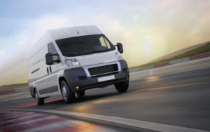 Caspian work truck going to a site to provide help and advanced technology solutions. Driving down blurry road or highway with sun setting or rising.