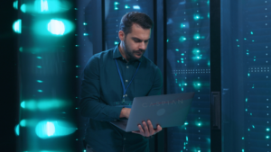 man on laptop with Caspian sticker monitoring server cabinets