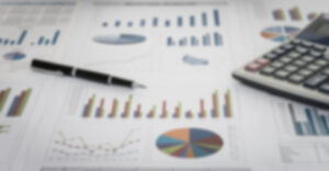 blurry photo of financial charts with pen