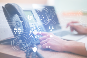 Hand pressing "2" key on PBX phone system, with capabilities such as VOIP and other features graphically highlighted.